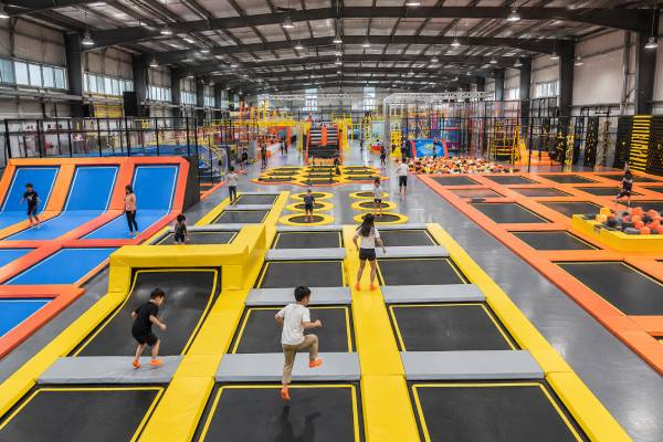 Large commercial indoor trampoline park with interconnected jumping beds, bantalan pelindung, angled trampolines and foam pit.
